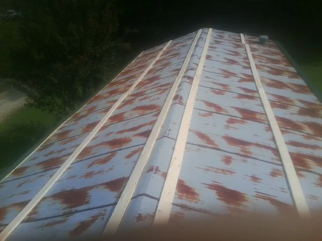 Rusted metal roof panels with new wood purlins before replacement — Storm Damage Roof Repair in Reed Point by Roofing Brothers