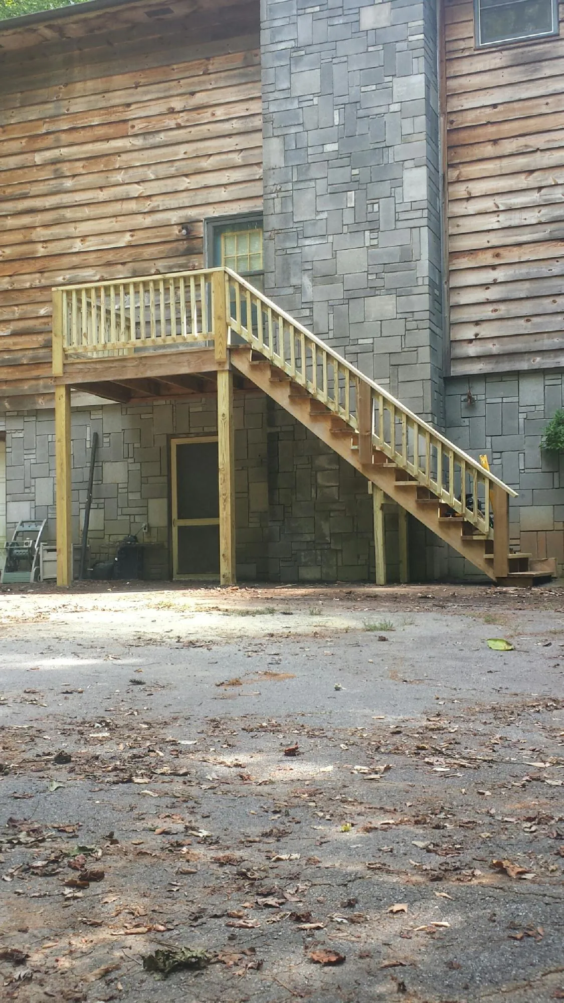 New pressure treated deck and stair landing on a log home in Reed Point