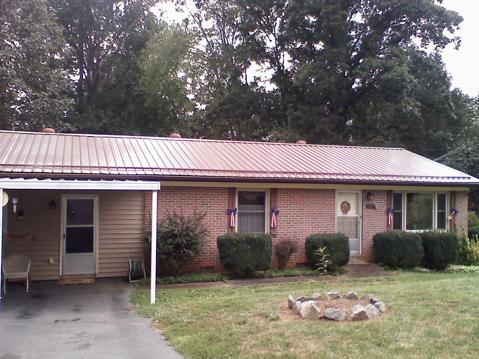 Bronze metal roof and carport on a brick ranch home — Roof Repair work by our crew in Reed Point